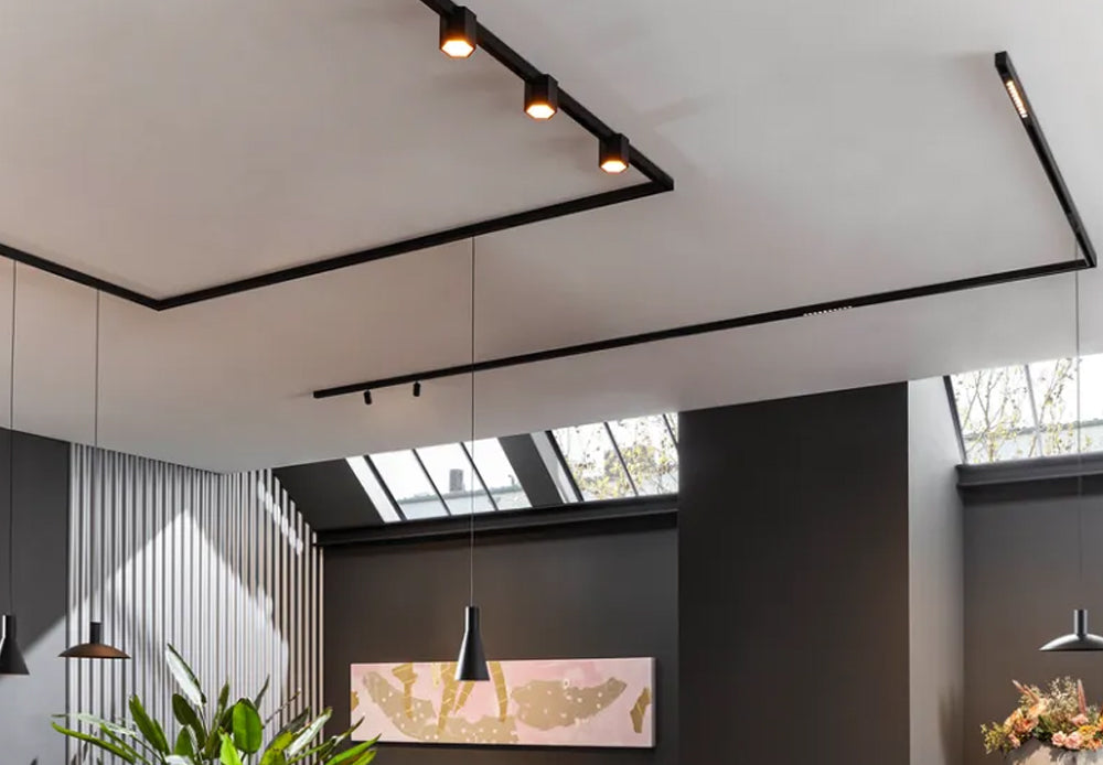 Modern interior with black track lighting and minimalist pendant lamps in a contemporary room.