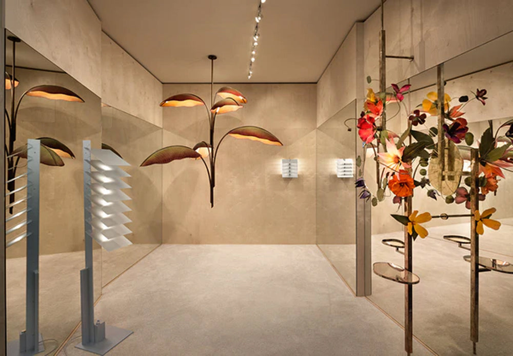 Modern art installation featuring leaf-shaped designer lamps and floral decor in a gallery