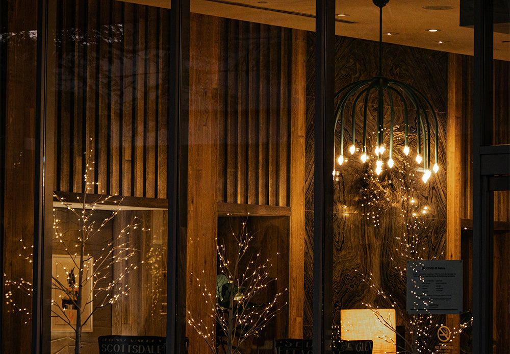 Luxury modern dome-shaped hanging light and decorative fairy light trees in a wood-paneled room