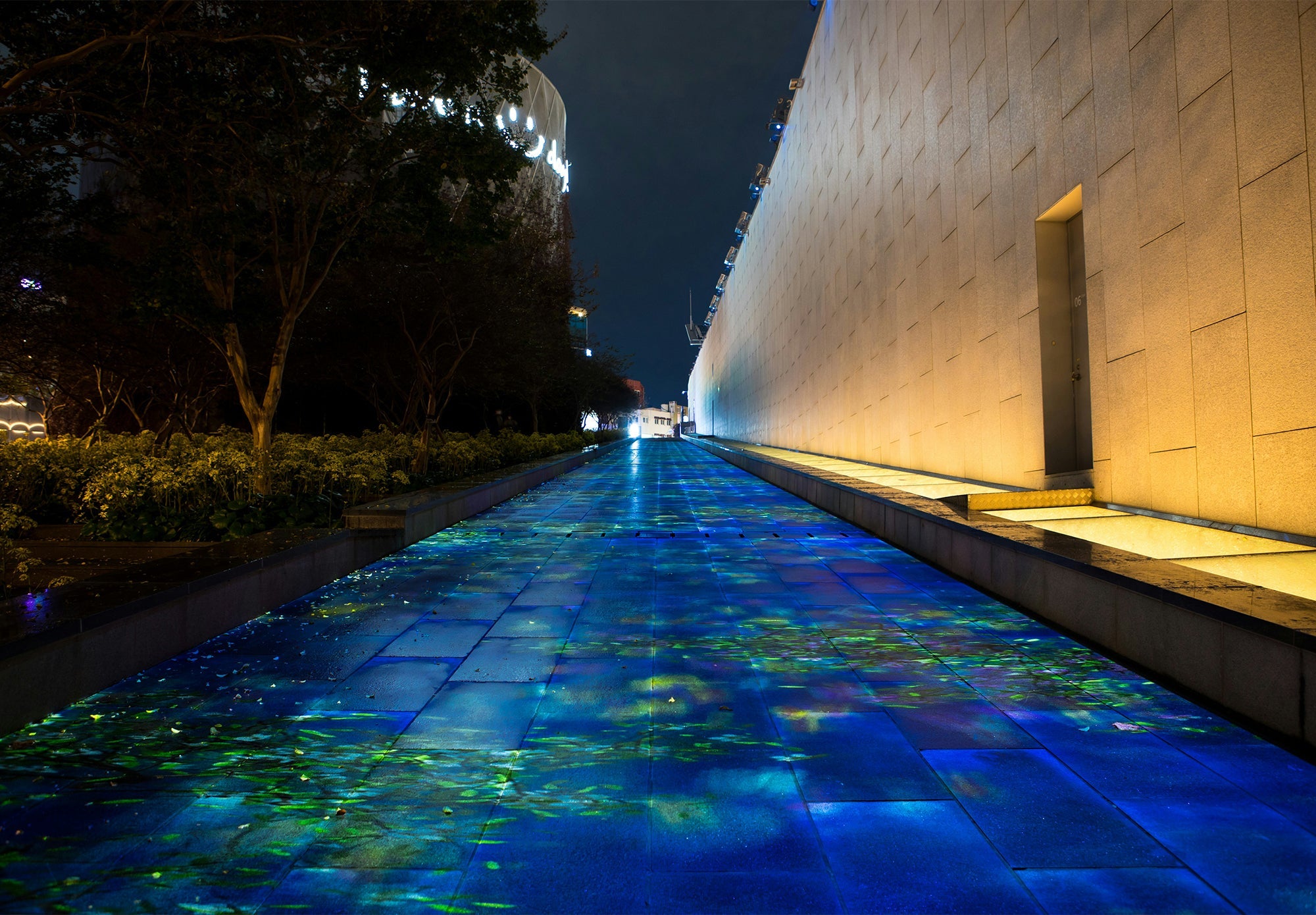 Modern architectural walkway with blue and green ambient accent lighting at night